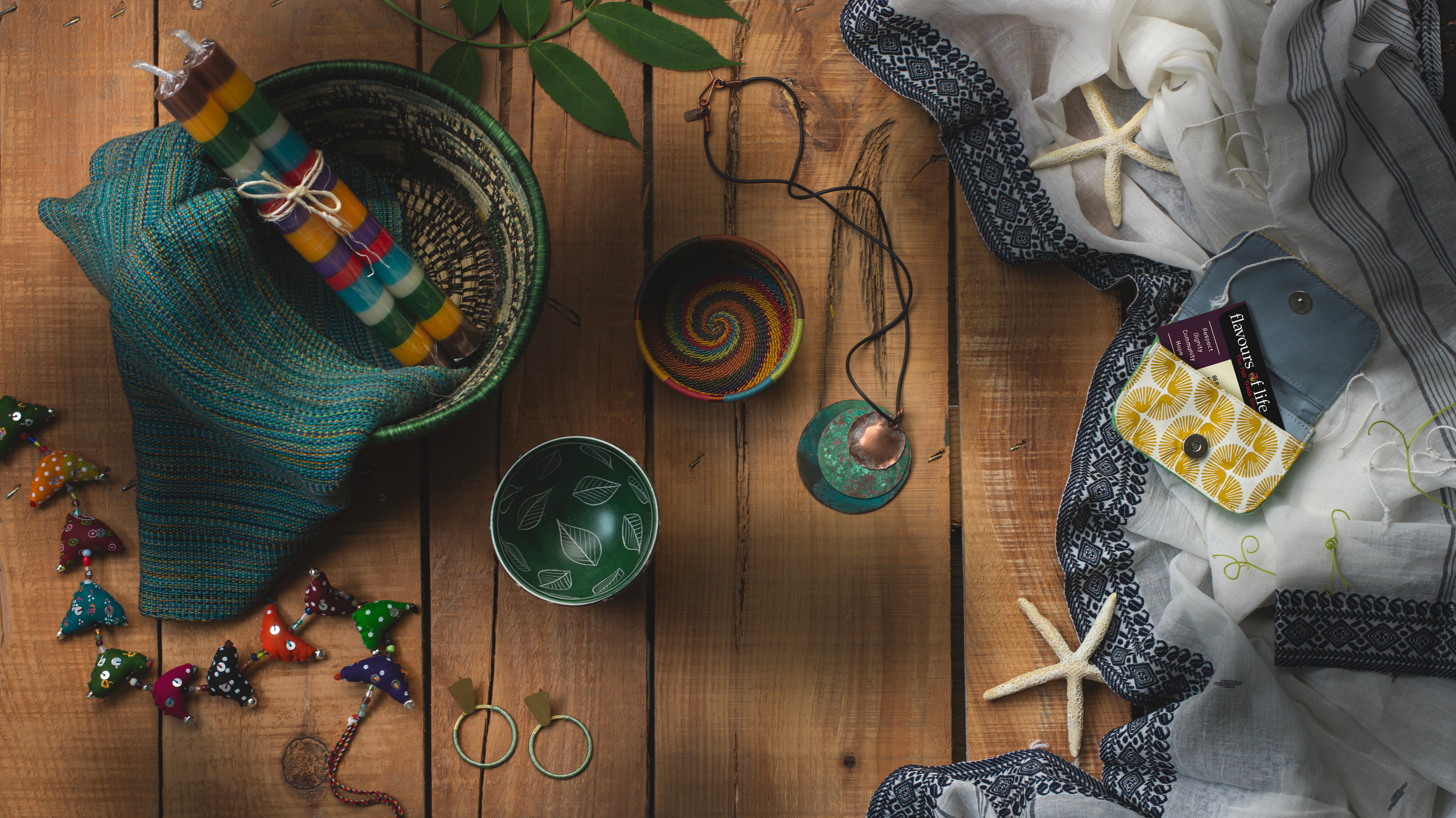 image of a collection of items sold at Flavours of life, including a wire bowl, candles, mobile, earrings, business card holder